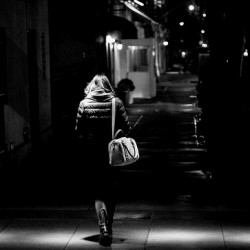 A lady walking in a dark street