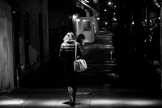 A lady walking in a dark street