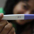 A lady holding a pregnancy test