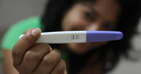 A lady holding a pregnancy test