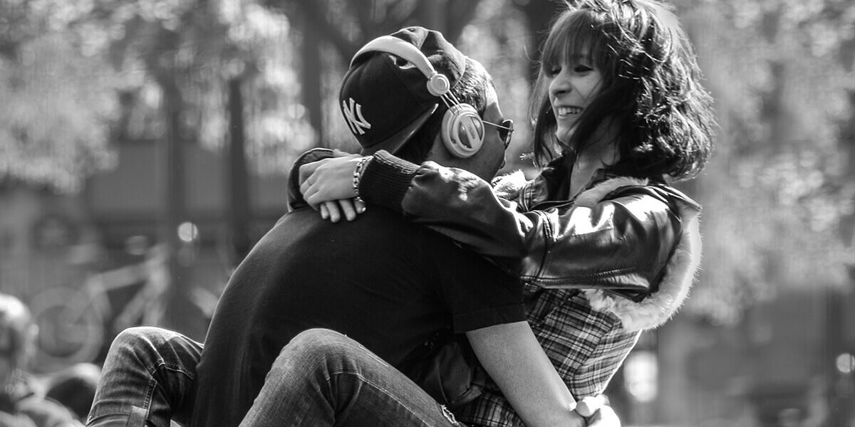 A passionate couple sit at the park.