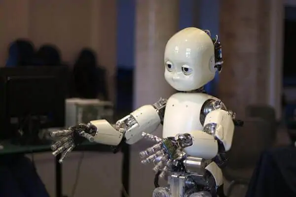 The photo displays iCub, a child-like humanoid robot.