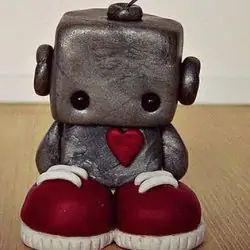 A sad little robot standing on the floor.
