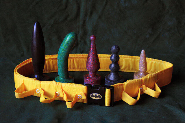 Glittery silicone phallic sex toys with a batman utility belt. 