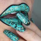 A woman with green-painted lips and nails.