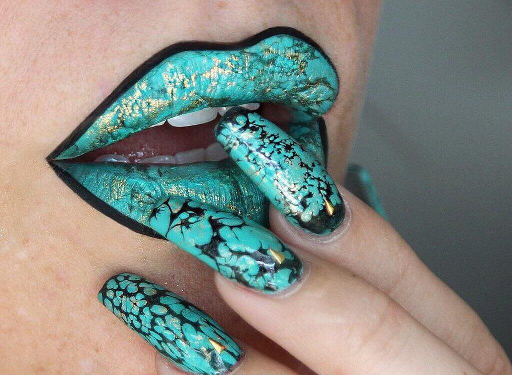 A woman with green-painted lips and nails.