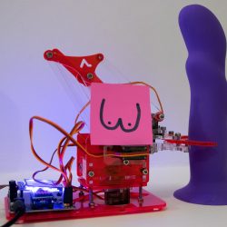 A robotic arm holds a purple dildo.