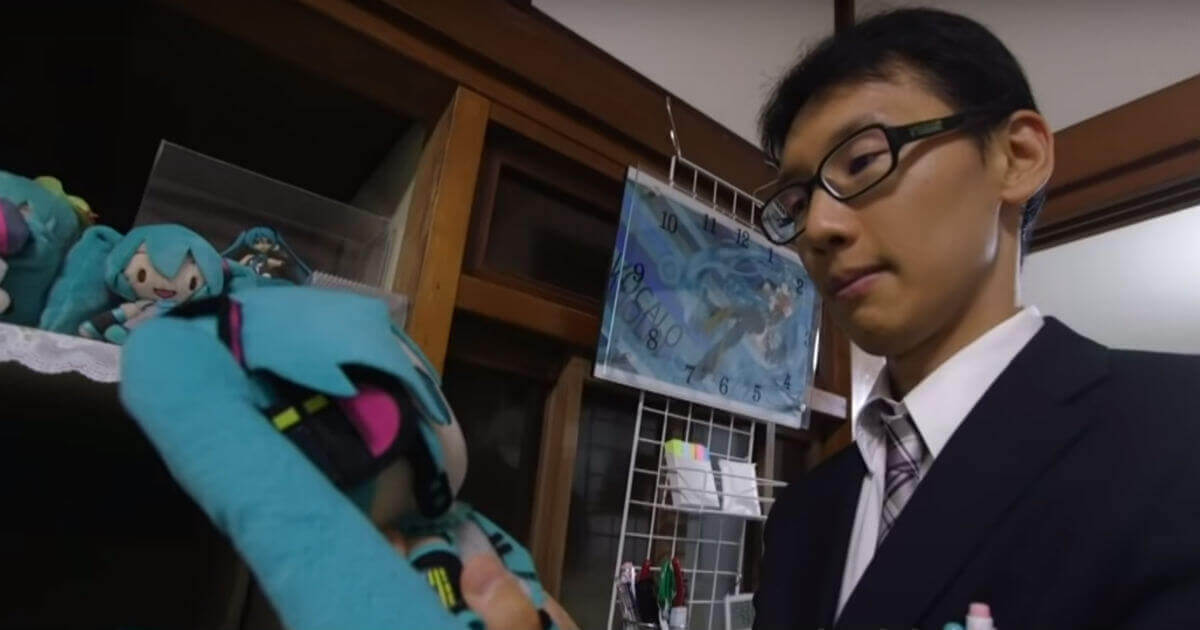 Japanese man holds a stuffed animal versions of his hologram wife.