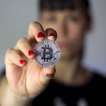 Girl holding silver Bitcoin