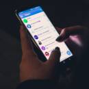 Closeup of a Telegram user scrolling the app on a smartphone.