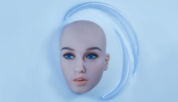 Kokeshis face and head, without hair, appears in a bath of white fluid.