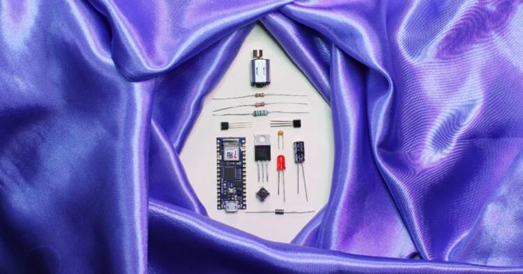 A purple satin sheet encircles disassembled electronic parts.