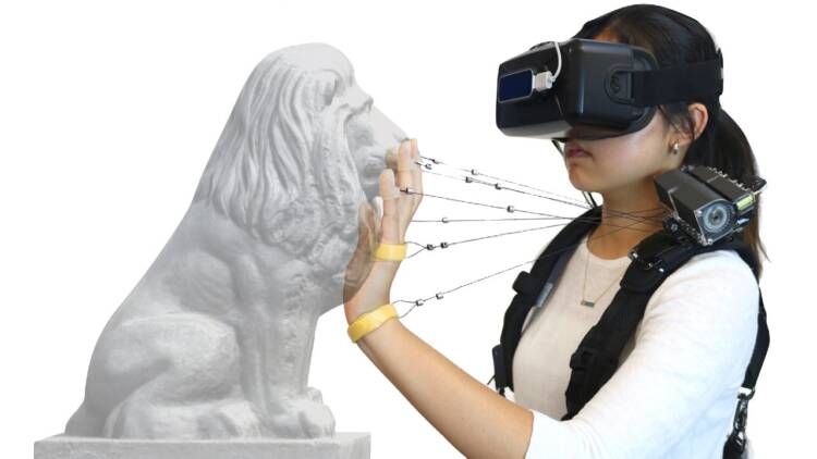 Model Displaying Cathy Fang's Wireality Virtual Reality with Worn Multi-String Haptics.