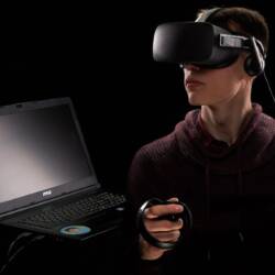 Image of a man using virtual reality devices and laptop
