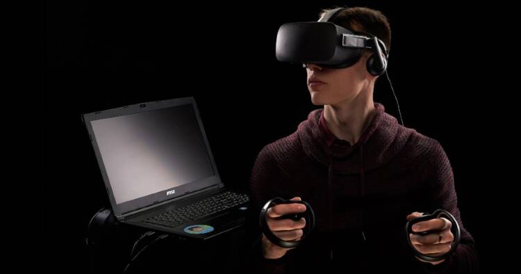 Image of a man using virtual reality devices and laptop