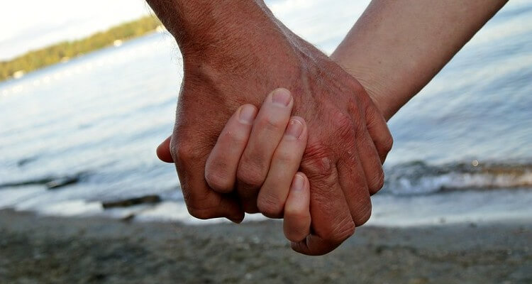 Screenshot of Holding Hands of Couple Over a Beach