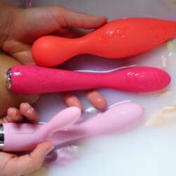 Image of a women in bath tub with sex toys in her hand
