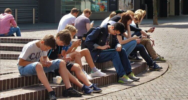 Group of people busy on their phone sidebarring others showing side effect of smartphones and social media