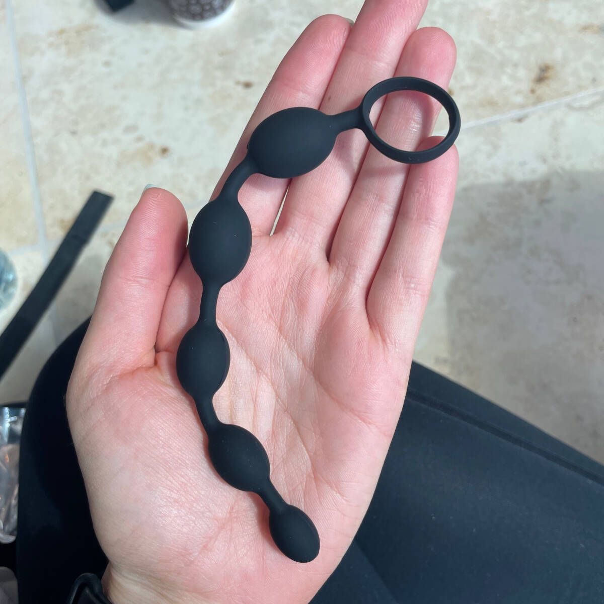 Image of palm holding low-tech sex toys silicone anal beads