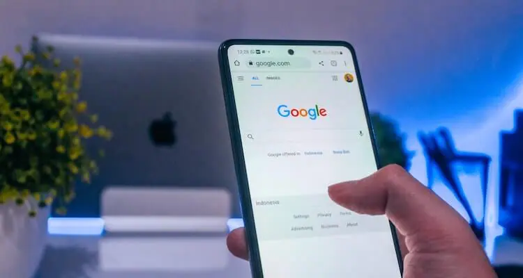 A phone lit up against a dark background, showing the Google search console.