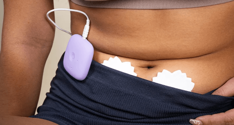 The Livia device in action. There's a purple device clipped to the underwear and then star-shaped pads fastened under the belly button.