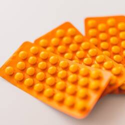 Orange packages of medications on table.