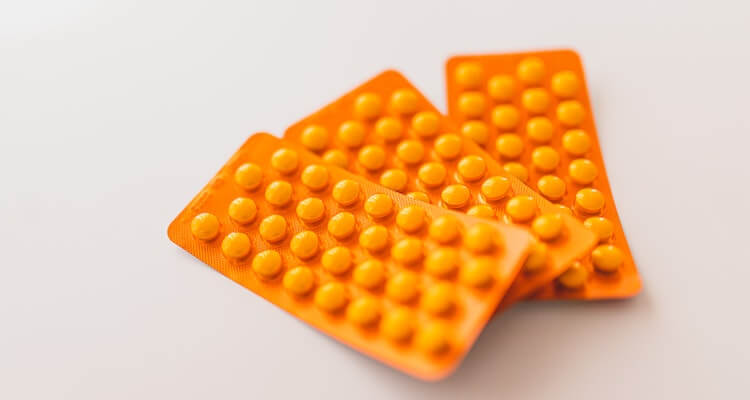 Orange packages of medications on table.