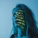 Woman in blue lighting with yellow binary code projected across her face.