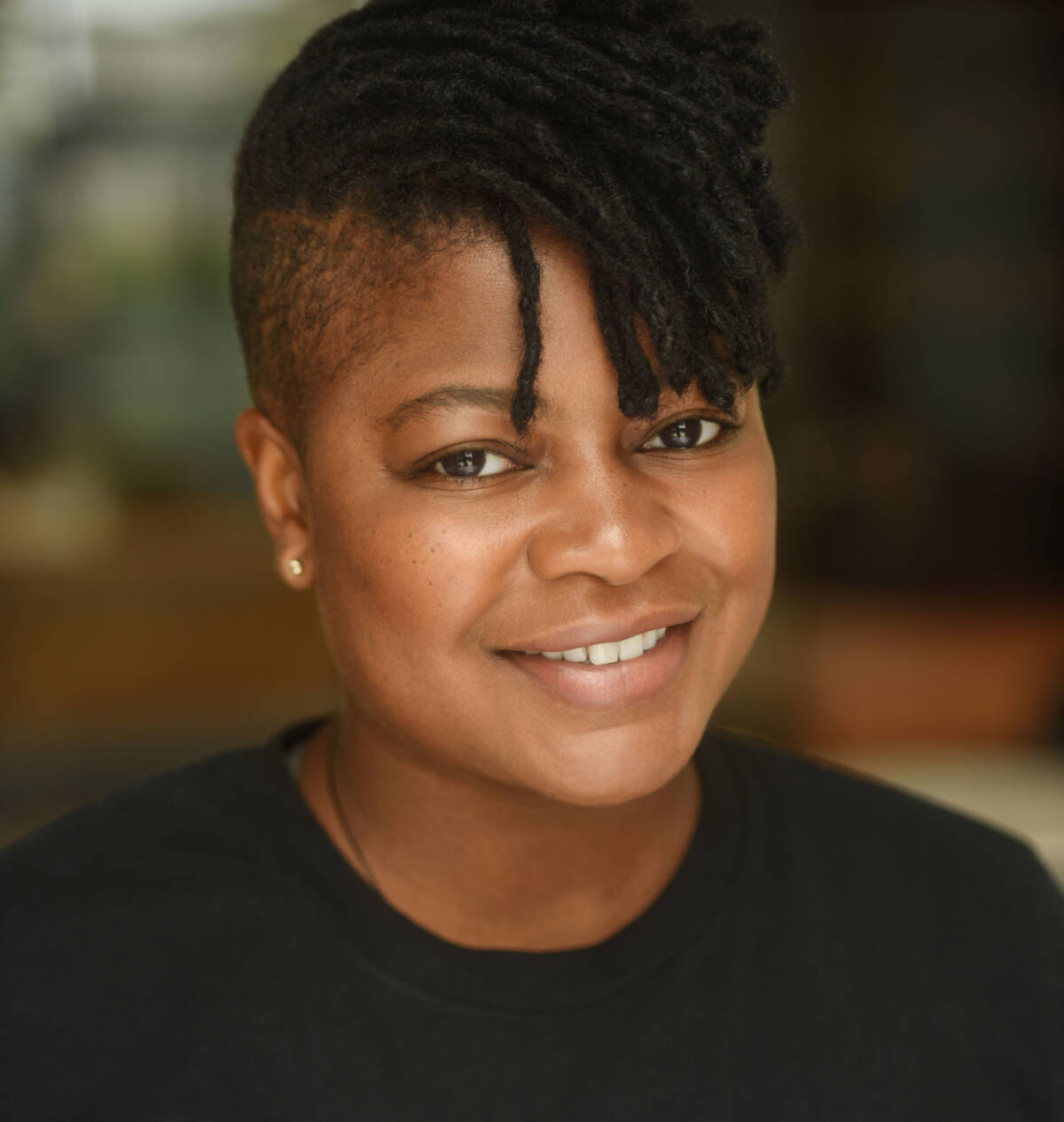 Headshot of Glenise smiling and wearing a black t-shirt.